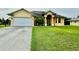 Single-Gathering home with a two-car garage and well-maintained lawn at 324 Santurce Ave, North Port, FL 34287