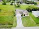 Aerial view of a single-Gathering house with a driveway and grassy yard at 324 Santurce Ave, North Port, FL 34287