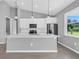 Modern kitchen with white cabinets, stainless steel appliances, and large island at 161 Mariner Ln, Rotonda West, FL 33947