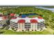 Aerial view of a waterfront condo building with red roofs and balconies at 10055 Links Ln # 206, Rotonda West, FL 33947