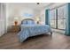 Guest bedroom with full bed, wood nightstands, and window with teal curtains at 404 Cypress Forest Dr, Englewood, FL 34223
