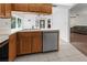 Kitchen boasts wood cabinets, a dishwasher, and views into the living room at 404 Cypress Forest Dr, Englewood, FL 34223