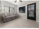Sunroom with tiled floors, sofa, and access to the backyard at 404 Cypress Forest Dr, Englewood, FL 34223