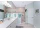 Bright bathroom featuring a glass-enclosed shower and a double sink vanity with modern fixtures at 552 Box Elder Ct, Englewood, FL 34223