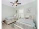 Light and airy bedroom with two twin beds, neutral decor, and a ceiling fan at 552 Box Elder Ct, Englewood, FL 34223