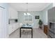 Cozy dining area featuring white cabinets, marble backsplash, a modern table, and natural light from the window at 552 Box Elder Ct, Englewood, FL 34223
