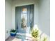 Close-up of an elegant front door with decorative glass, sidelights, and potted plants at 552 Box Elder Ct, Englewood, FL 34223