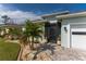 Close-up of the charming home's front entrance with beautiful landscaping and a screened entryway at 552 Box Elder Ct, Englewood, FL 34223