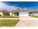 Charming single-story home with a manicured lawn, paver driveway, and an attached two-car garage at 552 Box Elder Ct, Englewood, FL 34223