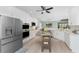 Open kitchen layout boasts stainless steel appliances, white cabinets, a central island, and an inviting breakfast nook at 552 Box Elder Ct, Englewood, FL 34223