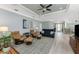 Spacious living room with light wood floors, leather furniture, and an open layout to the dining and entry at 552 Box Elder Ct, Englewood, FL 34223
