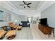 Open-concept living room boasts light wood floors, a ceiling fan, and seamless access to the kitchen and entryway at 552 Box Elder Ct, Englewood, FL 34223
