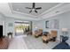 Bright living room featuring comfortable leather furniture, ceiling fan, and sliding glass doors to outdoor space at 552 Box Elder Ct, Englewood, FL 34223