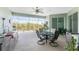 Outdoor living area features a ceiling fan, a table with four chairs, and a lovely backyard view at 552 Box Elder Ct, Englewood, FL 34223