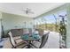 Inviting screened patio with dining table, outdoor kitchen, and views of lush landscaping at 552 Box Elder Ct, Englewood, FL 34223