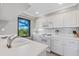 White kitchen with updated appliances and a window overlooking the ocean at 5700 Gulf Shores Dr # C157, Boca Grande, FL 33921