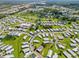 Aerial view of home in a mature community with trees, grassy spaces, and a community pool at 5704 Holiday Park Blvd, North Port, FL 34287