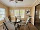 Cozy dining room with four chairs, glass table, wood-paneled walls, and bright natural light at 5704 Holiday Park Blvd, North Port, FL 34287