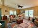 Comfortable living room with a ceiling fan, hardwood floors, and ample natural light at 5704 Holiday Park Blvd, North Port, FL 34287