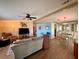 Open-concept living room with a ceiling fan, hardwood floors, and a cozy dining area at 5704 Holiday Park Blvd, North Port, FL 34287