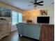 Comfortable living room features an area rug, a ceiling fan, and a flat-screen TV at 5704 Holiday Park Blvd, North Port, FL 34287