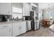 White kitchen with stainless steel appliances and tile backsplash at 9085 Pinehaven Way, Englewood, FL 34224