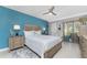 Main bedroom with a light teal accent wall, queen bed, and access to the balcony at 1551 Beach Rd # 213, Englewood, FL 34223