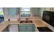 Bright kitchen features light teal cabinets, double sink, and modern backsplash at 13528 Martha Ave, Port Charlotte, FL 33981