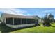 Large screened porch overlooking a grassy backyard with a grill at 13528 Martha Ave, Port Charlotte, FL 33981