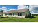 Light beige house with green trim, brown roof, and a well-maintained lawn at 13528 Martha Ave, Port Charlotte, FL 33981