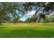 Landscaped golf course with mature trees and walking paths at 11044 Hogan Cir, Englewood, FL 34223