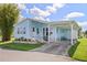 Light blue manufactured home with carport and landscaping at 5704 Holiday Park Blvd, North Port, FL 34287