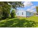 Manufactured home with grassy backyard and partial tree cover at 5704 Holiday Park Blvd, North Port, FL 34287