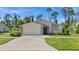 Single-story home with attached garage and landscaping at 404 Cypress Forest Dr, Englewood, FL 34223
