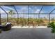 Spacious screened lanai with patio furniture and lush landscaping views at 552 Box Elder Ct, Englewood, FL 34223