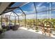 Relaxing screened lanai featuring wicker furniture and potted plants at 552 Box Elder Ct, Englewood, FL 34223