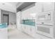 Modern kitchen with white cabinets, granite countertops, and blue glass tile backsplash at 14344 Amestoy Ave, Port Charlotte, FL 33981