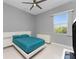 Bright bedroom with teal bedding and a ceiling fan at 14344 Amestoy Ave, Port Charlotte, FL 33981
