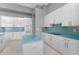 Modern kitchen with white cabinets, granite countertops, and blue glass tile backsplash at 14344 Amestoy Ave, Port Charlotte, FL 33981