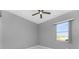 Spacious bedroom with grey walls, ceiling fan, and large window at 14344 Amestoy Ave, Port Charlotte, FL 33981