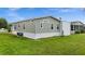 Side view of tan mobile home with grassy yard at 9085 Pinehaven Way, Englewood, FL 34224
