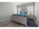 Bedroom with a queen bed, nightstand and wood-look floors at 9085 Pinehaven Way, Englewood, FL 34224