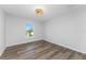 Simple bedroom with wood-look floors and a window at 4199 Hollis Ave, Port Charlotte, FL 33953