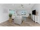Bright living room featuring comfy seating, large windows, and wood-look floors at 4199 Hollis Ave, Port Charlotte, FL 33953
