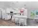 Bright kitchen featuring white cabinets, an island with seating, and hardwood floors at 4199 Hollis Ave, Port Charlotte, FL 33953