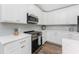 Modern white kitchen with stainless steel appliances and an island at 4199 Hollis Ave, Port Charlotte, FL 33953