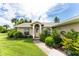 House exterior featuring a landscaped lawn, walkway, and a light beige color scheme at 13511 Foresman Blvd, Port Charlotte, FL 33981