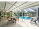 Relaxing pool area with screened enclosure, patio furniture, and view of the canal at 13511 Foresman Blvd, Port Charlotte, FL 33981