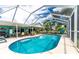 Inviting screened-in pool with a large patio area and outdoor seating at 13511 Foresman Blvd, Port Charlotte, FL 33981
