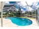 Relaxing kidney-shaped pool with screened enclosure overlooking a lake at 13511 Foresman Blvd, Port Charlotte, FL 33981